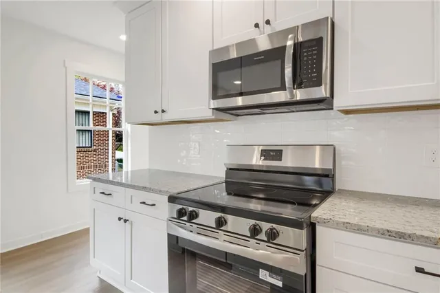 a kitchen with stainless steel appliances granite countertop a stove microwave and sink