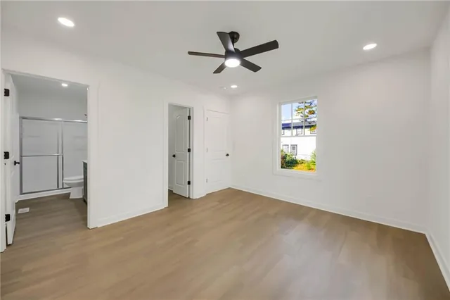 an empty room with window and ceiling fan