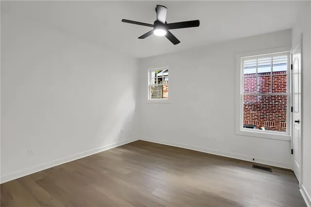 an empty room with a window and a ceiling fan