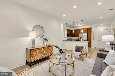 a living room with furniture a table and kitchen view