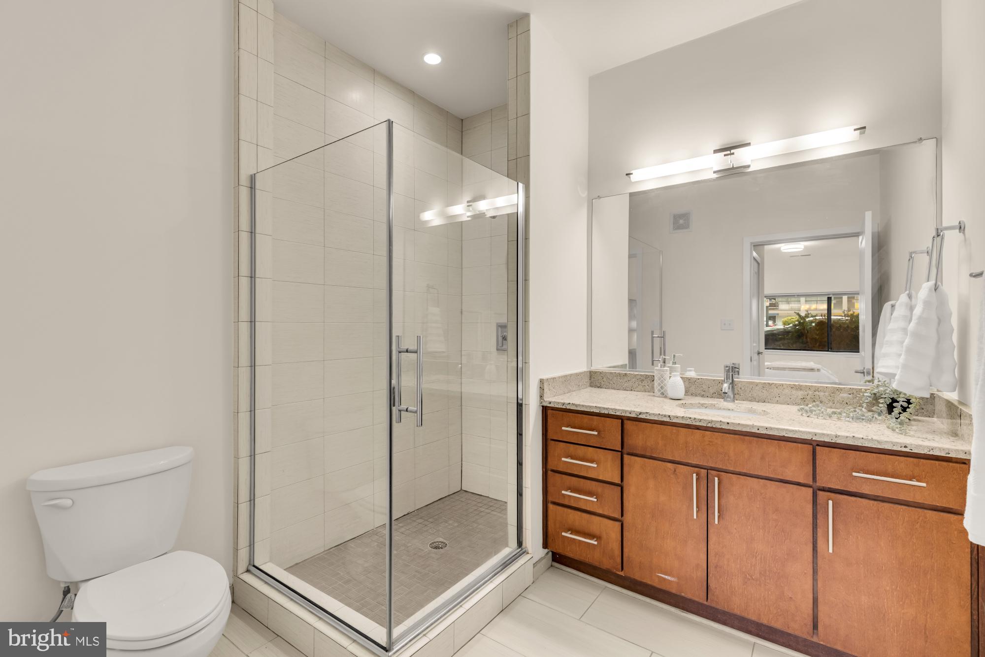 8005 13th Street, Unit 104 Silver Spring, MD 20910 - Photo 22 of 34 a bathroom with a shower sink mirror and toilet