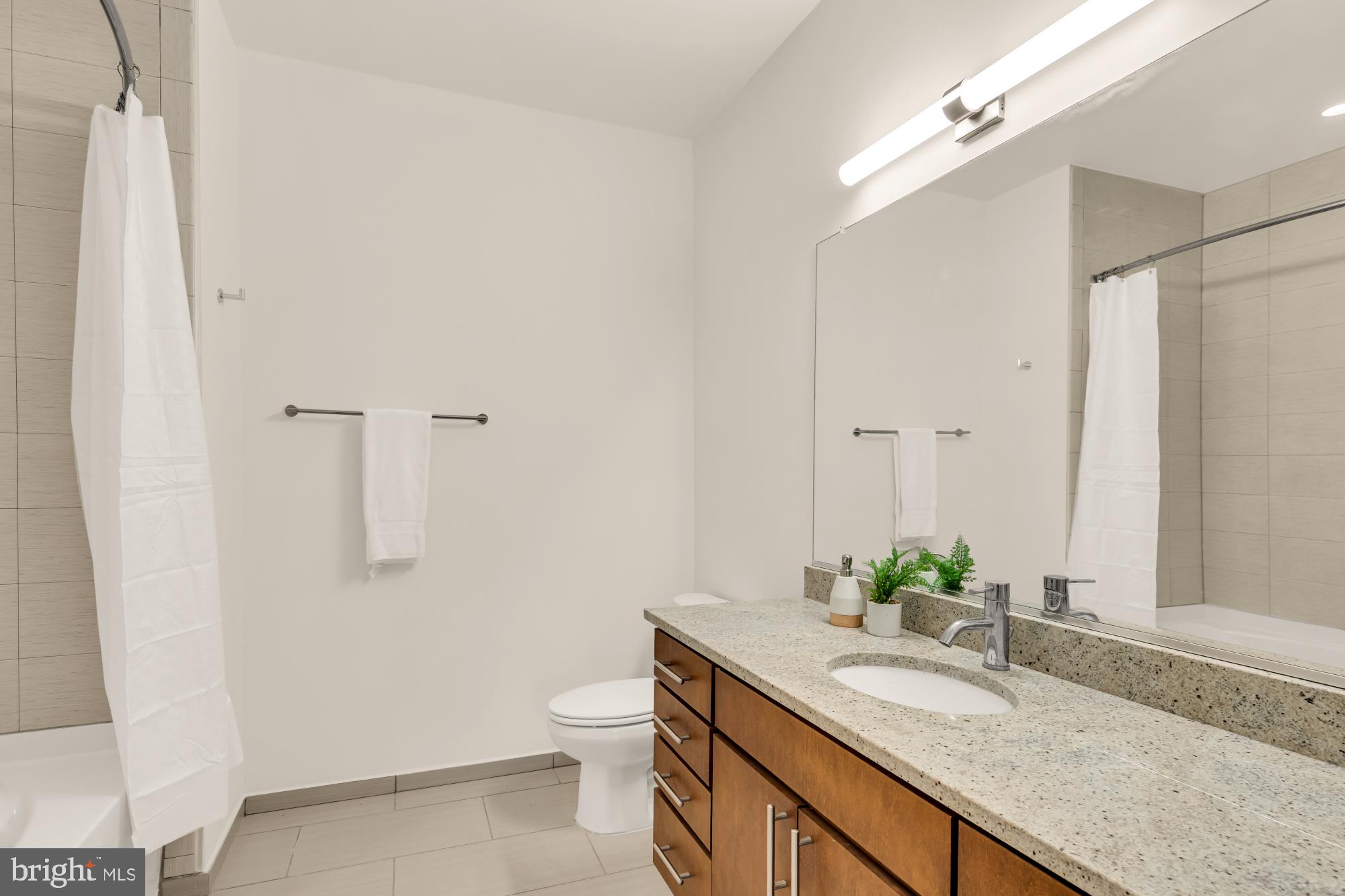 8005 13th Street, Unit 104 Silver Spring, MD 20910 - Photo 25 of 34 a bathroom with a granite countertop sink and a mirror