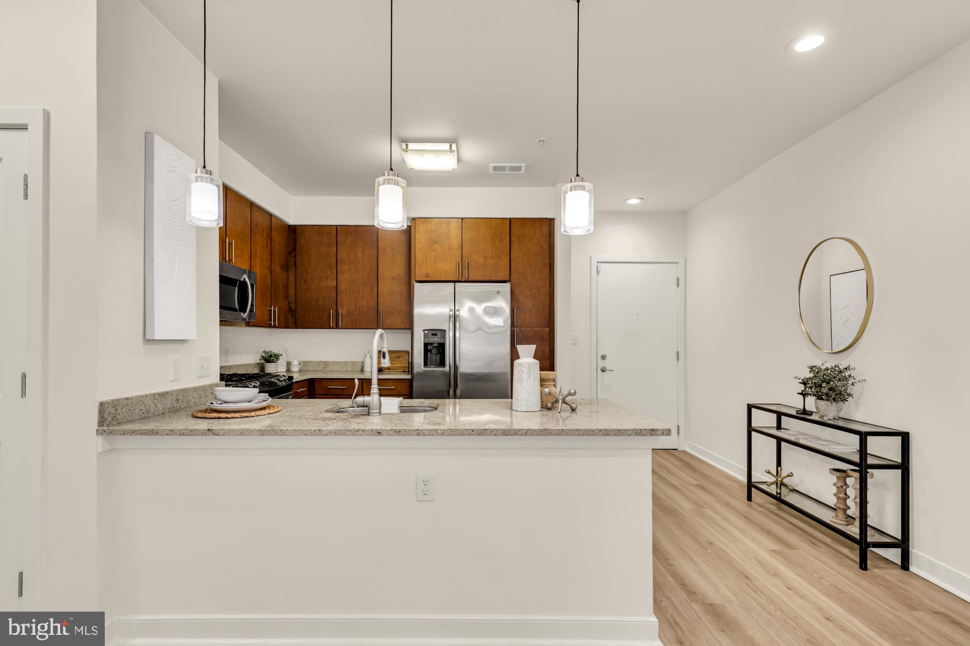 8005 13th Street, Unit 104 Silver Spring, MD 20910 - Photo 10 of 34 a kitchen with kitchen island granite countertop a sink cabinets and stainless steel appliances