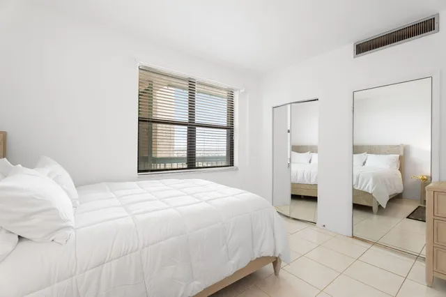 a bedroom with a bed and a large mirror