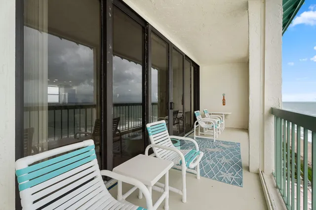 a view of a chairs and table in the balcony
