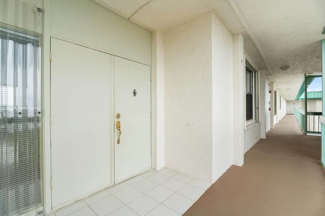 a view of a hallway with wooden floor and closet