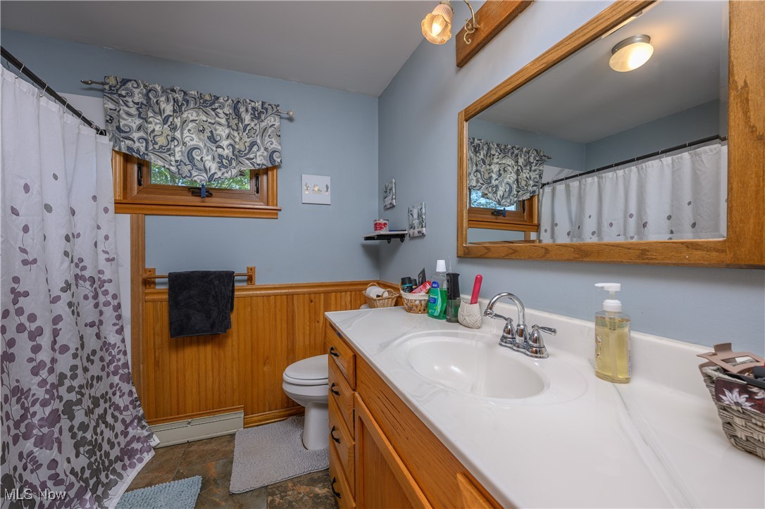 3015 Avalon Road Northwest Carrollton, OH 44615 - Photo 28 of 35 Bathroom with wooden walls, a wainscoted wall, vanity, a shower with shower curtain, and dark stone finish floors