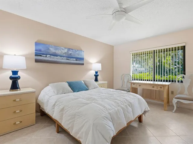 a bedroom with a bed and a lamp on dresser