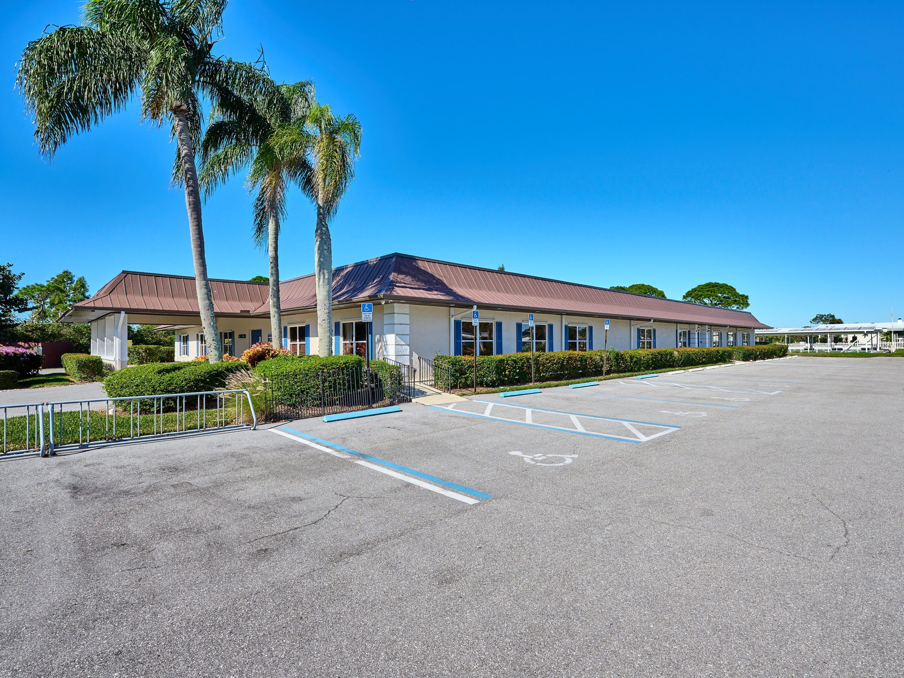 6977 Southeast Delegate Street Hobe Sound, FL 33455 - Photo 59 of 60 a front view of a house with a garden and trees