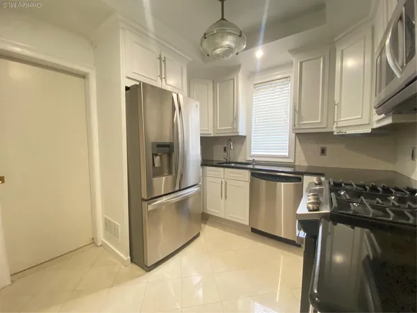 a kitchen with granite countertop a refrigerator oven a sink and dishwasher