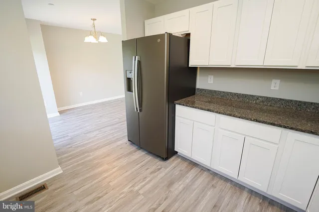 a kitchen with granite countertop wooden cabinets a sink and a window