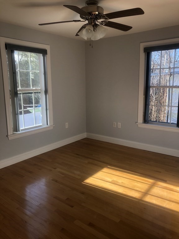 10-12 Tanglewood Road Boston, MA 02126 - Photo 6 of 17 a view of an empty room with wooden floor and a window