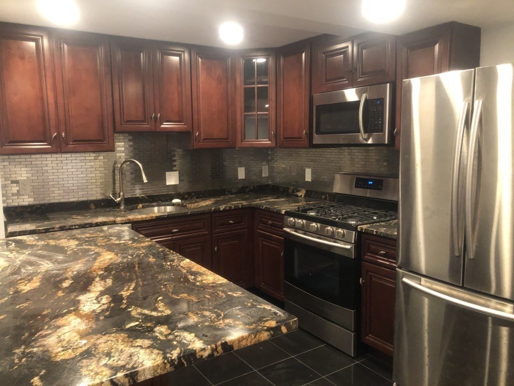 10-12 Tanglewood Road Boston, MA 02126 - Photo 8 of 17 a kitchen with stainless steel appliances granite countertop a refrigerator and a stove
