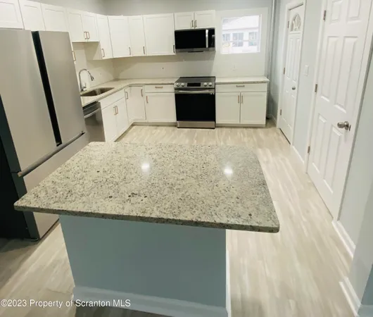 a kitchen with stainless steel appliances granite countertop a sink and a stove