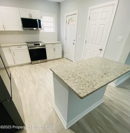 a kitchen with stainless steel appliances kitchen island granite countertop a sink stove and refrigerator
