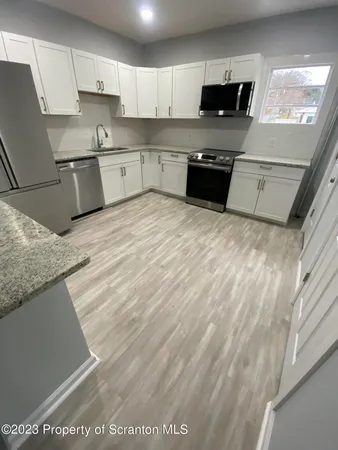 a kitchen with granite countertop cabinets stainless steel appliances and a counter space