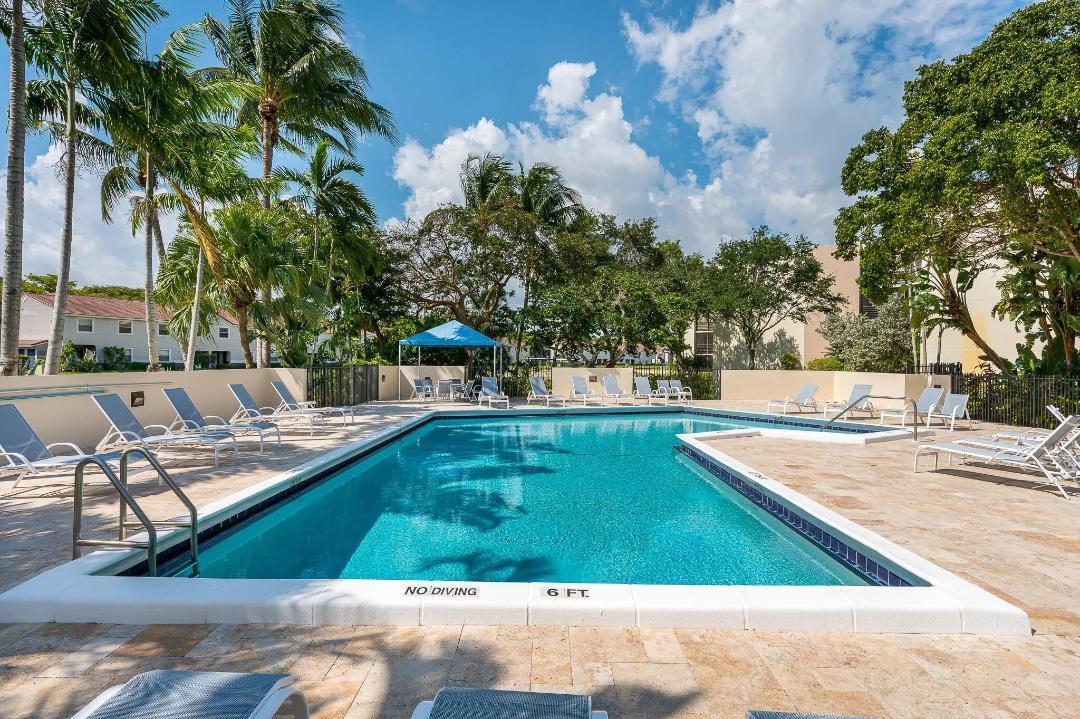 5700 Camino Del Sol, Unit 201 Boca Raton, FL 33433 - Photo 14 of 17 a view of a swimming pool with a patio