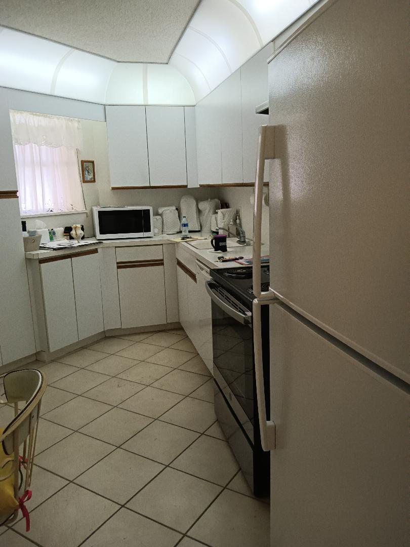 5700 Camino Del Sol, Unit 201 Boca Raton, FL 33433 - Photo 6 of 17 a kitchen with a sink cabinets and stainless steel appliances