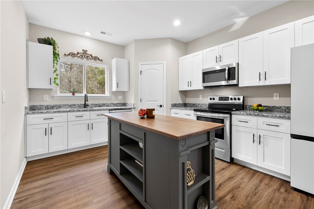 102 Colonial Court Pendleton, SC 29670 - Photo 12 of 30 This bright kitchen features wood flooring and a central island, perfect for culinary endeavors.