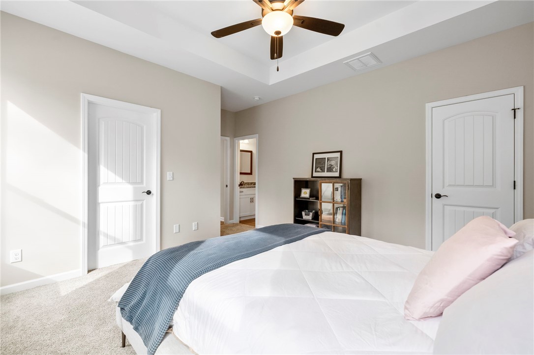 102 Colonial Court Pendleton, SC 29670 - Photo 17 of 30 This inviting bedroom features a tray ceiling, soft carpet, and easy access to a full bathroom.
