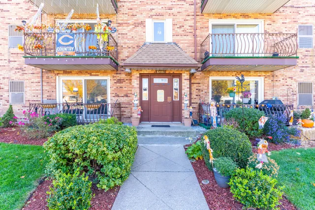 a view of a brick building with a lot of flower plants