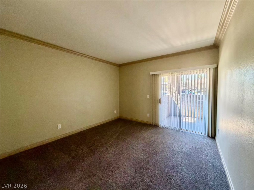 5525 West Flamingo Road, Unit 1019 Las Vegas, NV 89103 - Photo 14 of 18 A spacious living area with crown molding and access to an outdoor patio.