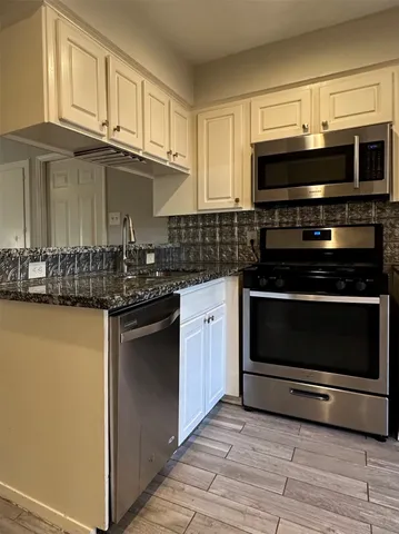 a kitchen with stainless steel appliances a stove a microwave and sink