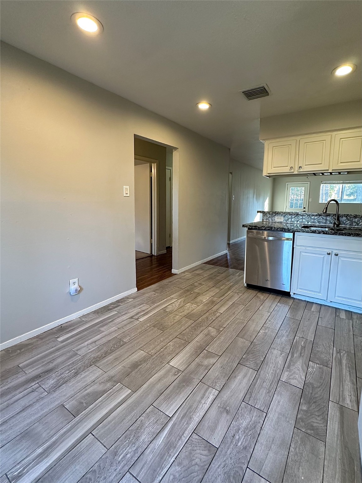 3223 Brooktree Lane Spring, TX 77380 - Photo 6 of 30 an empty room with wooden floor and kitchen view