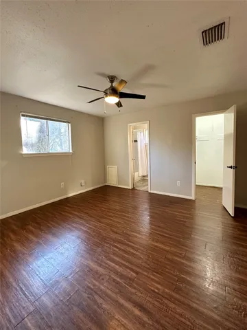 a view of a livingroom with wooden floor and a ceiling fan