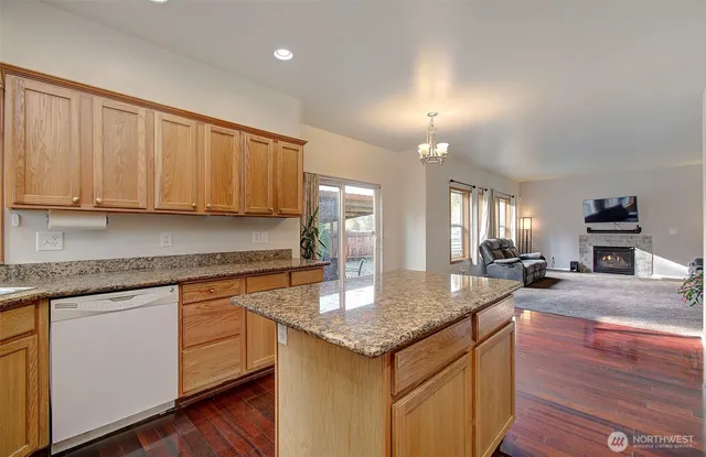 a kitchen with granite countertop a sink cabinets and wooden floor