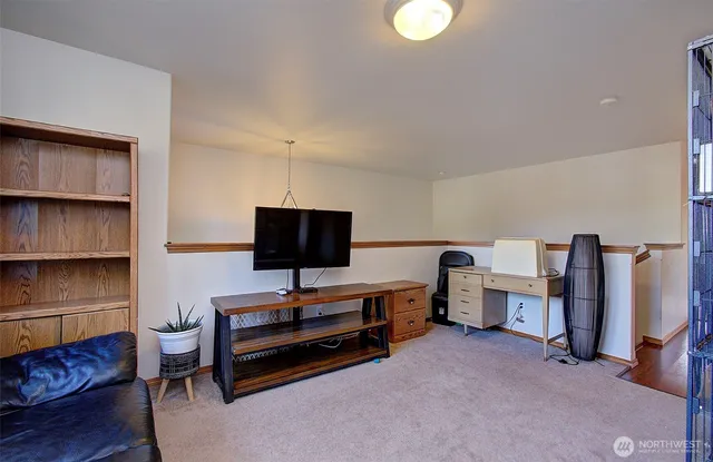 a living room with furniture a flat screen tv and gym equipment