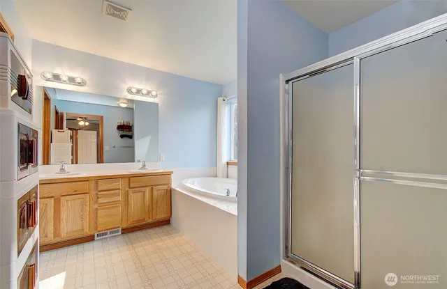 a large bathroom with a tub sink shower and mirror
