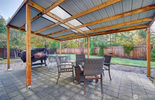 a view of a patio with a table chairs and a backyard