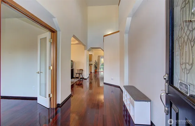 a view of a hallway with wooden floor and livingroom with furniture