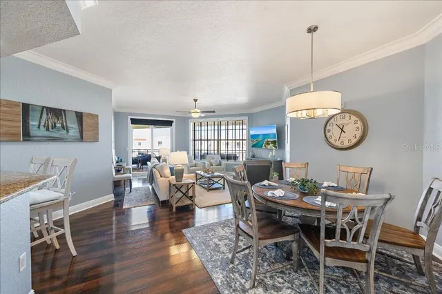 a view of a dining room and livingroom with furniture clock and wooden floor