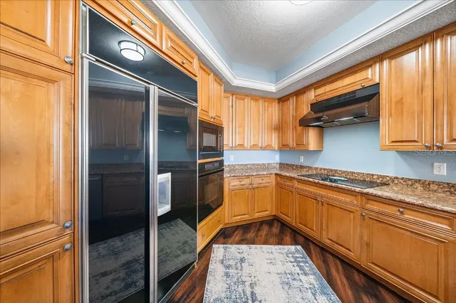 a kitchen with granite countertop stainless steel appliances a sink and cabinets