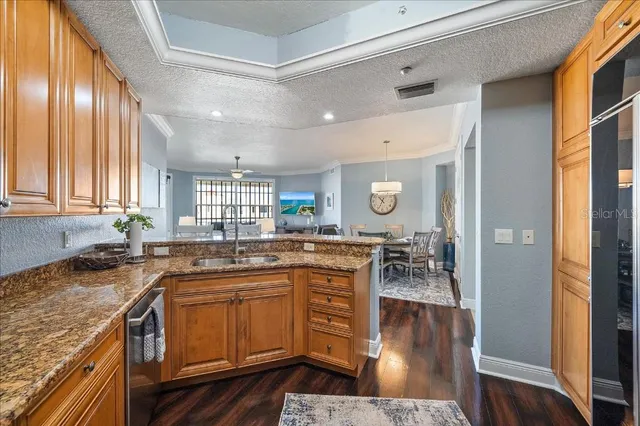 a kitchen with granite countertop a sink stove and cabinets