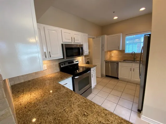 a kitchen with stainless steel appliances a microwave a sink and a stove