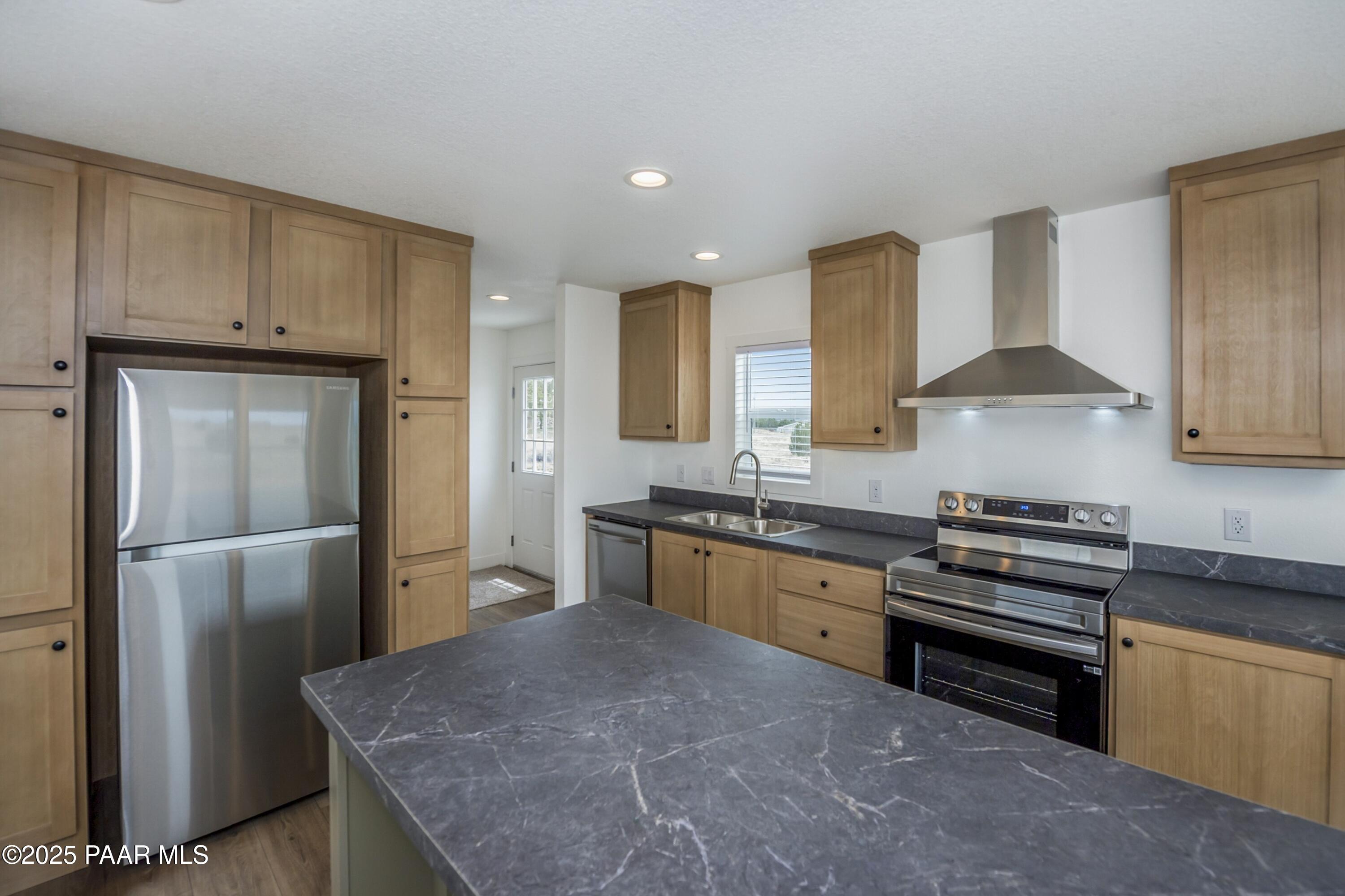 25671 St John Road Paulden, AZ 86334 - Photo 8 of 24 a kitchen with stainless steel appliances granite countertop a stove a refrigerator and a sink
