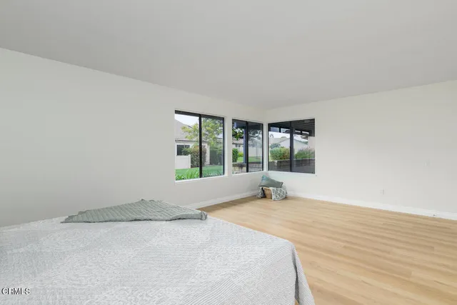 a large white bed in a room next to a window