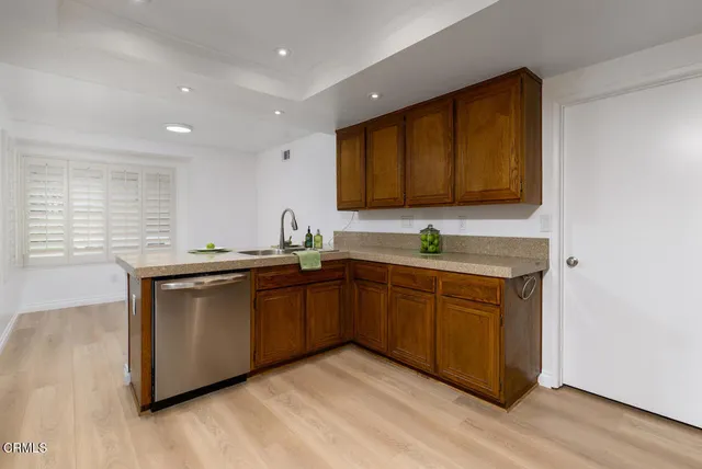 a kitchen with granite countertop a sink cabinets and stainless steel appliances
