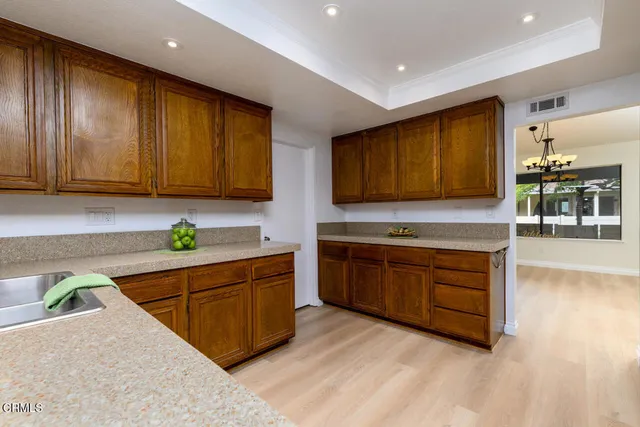 a kitchen with stainless steel appliances granite countertop wooden cabinets a stove top oven a sink and dishwasher