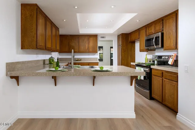 a kitchen with stainless steel appliances kitchen island granite countertop a sink stove and microwave