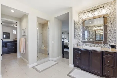 a walk in closet with wooden floor