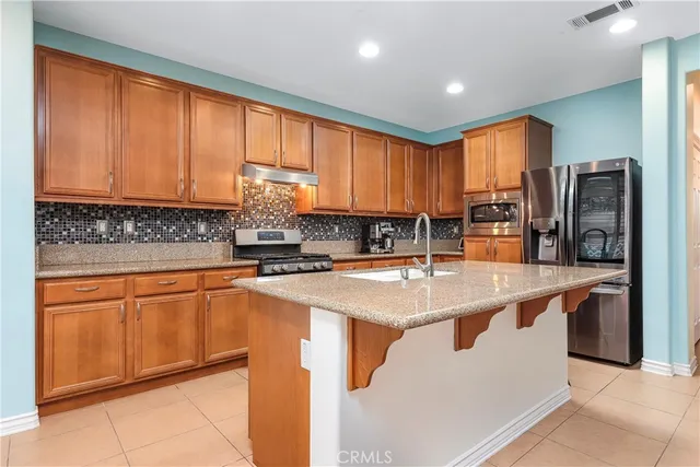 a kitchen with stainless steel appliances granite countertop refrigerator sink and cabinets