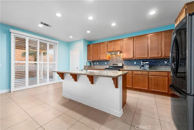 a kitchen with stainless steel appliances granite countertop a stove a sink a microwave and a refrigerator