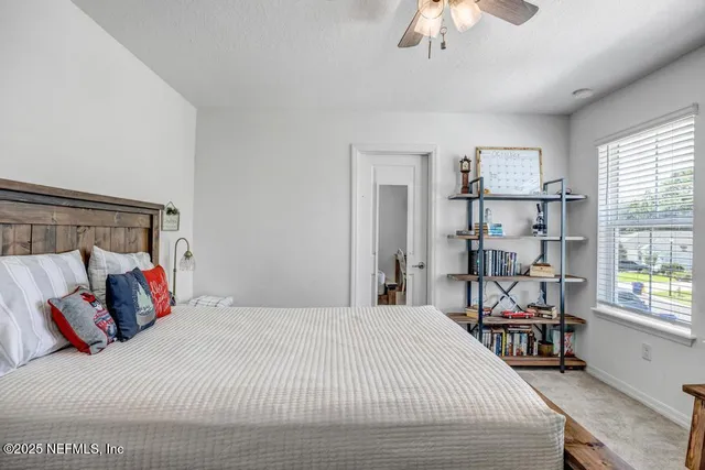 a bedroom with a bed a chandelier and a dresser