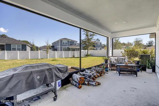 a living room with furniture floor to ceiling window and an outdoor view