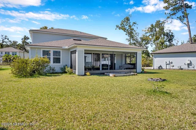 a view of a house with a backyard and a tree