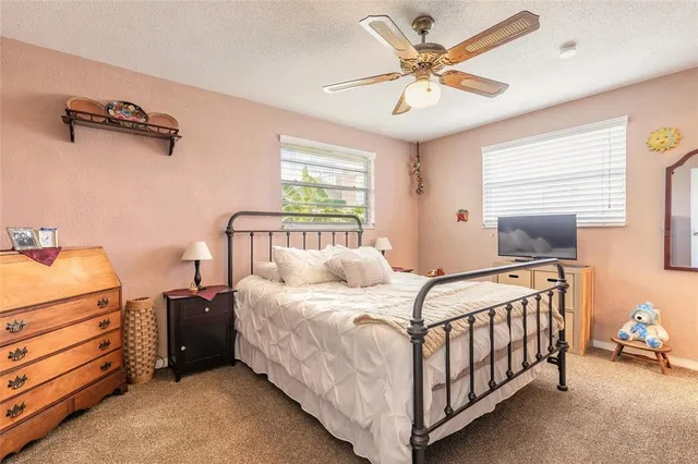 a bedroom with a bed and a ceiling fan